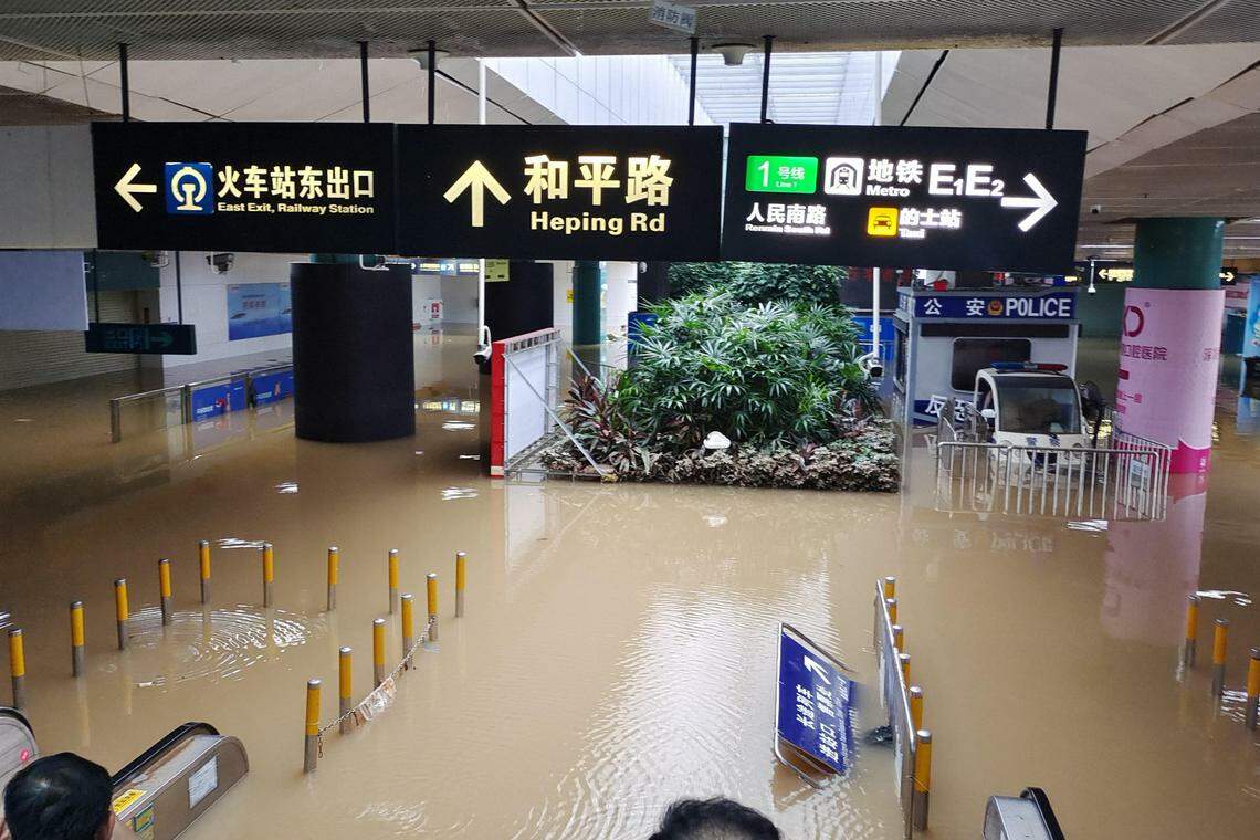 受暴雨影响,深圳火车站的负一楼进出站口被水淹,乘客无法正常进出站,一度有约百人被滞留在站内。(中新社)