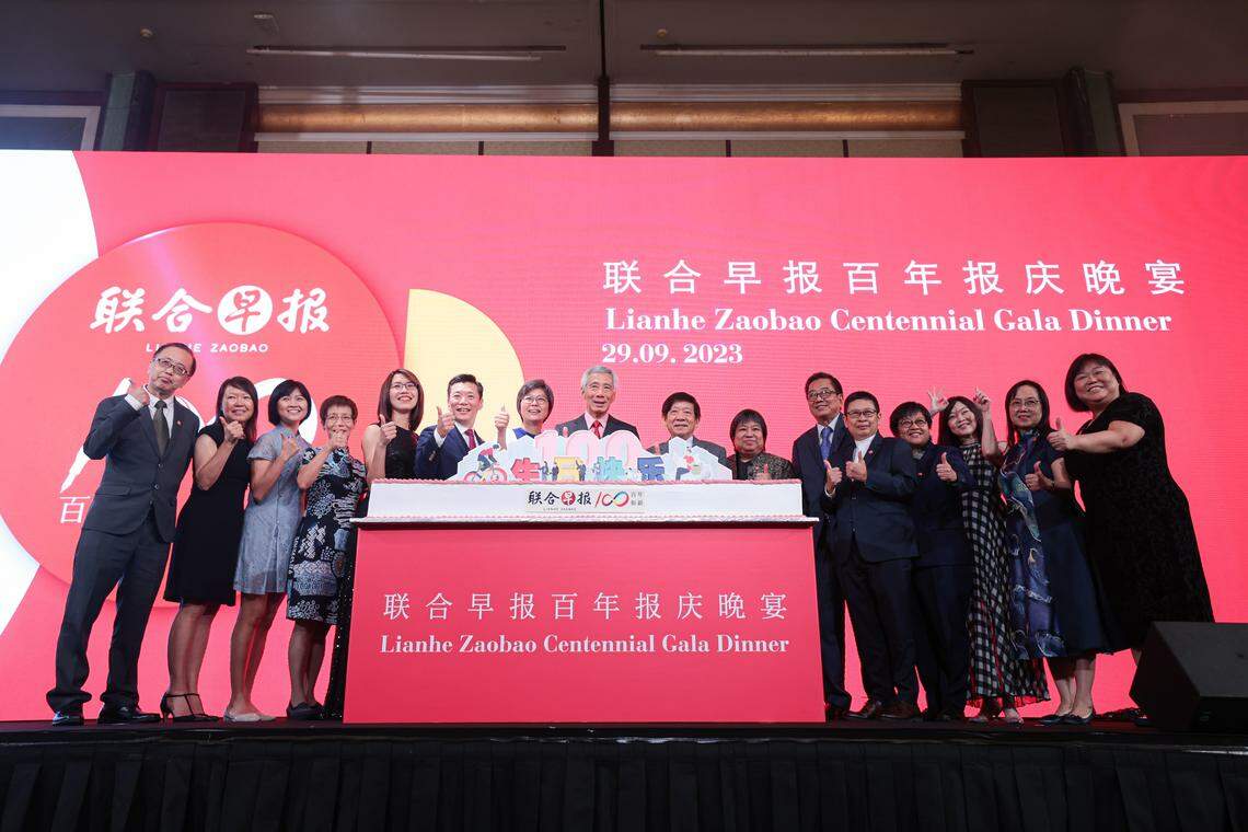 《联合早报》百年报庆晚宴9月29日在香格里拉大酒店举行,主宾新总理李显龙(右八)在切蛋糕仪式后,同新报业媒体和《联合早报》高层合照留念。左起:《联合早报》副总编辑王彼得、副总编辑郭思满、助理总编辑洪奕婷、副总编辑吴新慧、华文媒体集团营运总编辑罗文燕、《联合早报》总编辑吴新迪、华文媒体集团社长李慧玲、新报业媒体主席许文远、总裁张丽琳、《联合早报》前总编辑林任君、《联合早报》执行总编辑韩咏梅、副总编辑韩咏红、副总编辑兼副刊主任胡文雁、助理总编辑谭德婷,以及助理总编辑郭丽娟。(李冠卫摄)