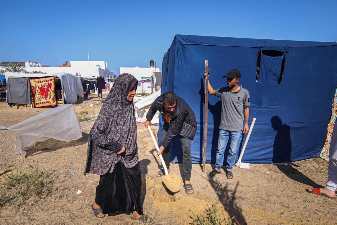 星期五在联合国近东巴勒斯坦难民救济和工程处(UNRWA)在加沙地带汗尤尼斯西部的一个难民营,工作人员正准备为难民搭建更多帐篷。(彭博社)
