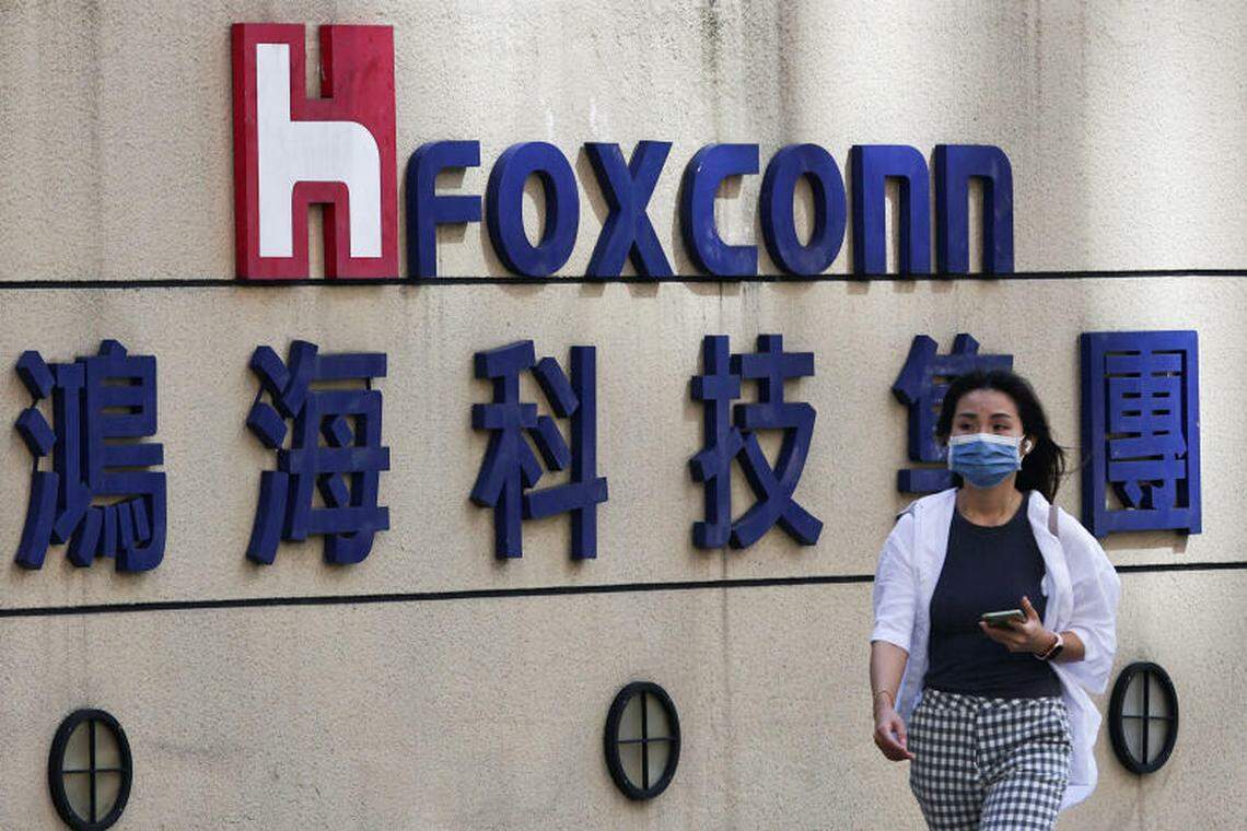 一名戴着口罩的女子2022年11月9日路过鸿海位于台北的办公室。(路透社)