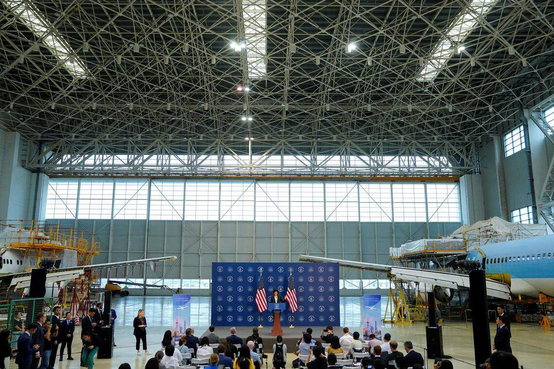 美国商务部长雷蒙多8月访华时,在上海波音公司的改装维修工厂开新闻发布会。两架巨大的波音737客机停放在她身后。(路透社)