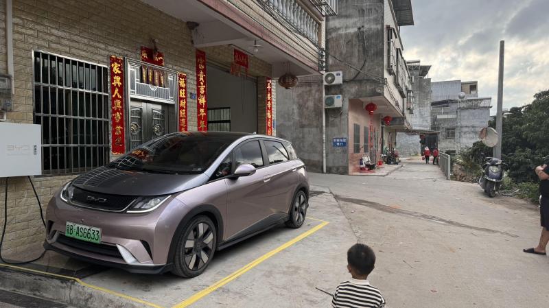 深圳酒吧从业者邓浩文2021年买了一辆比亚迪“海豚”电动汽车。他在充电桩充电每度电0.4元,平均每100公里只花10元。(受访者提供)