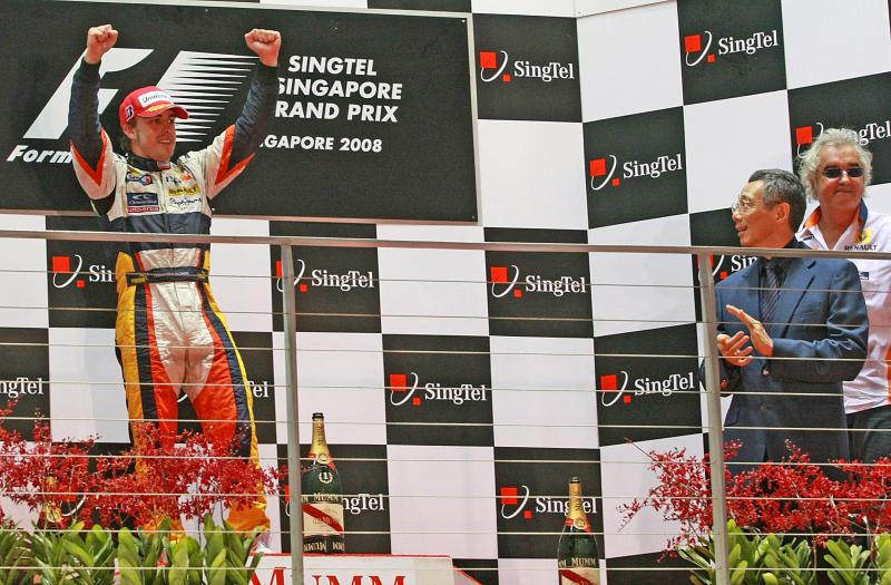 世界一级方程式(F1)赛车首届新电信新加坡大奖赛正赛,2008年9月28日在滨海湾举行。雷诺车队西班牙籍赛车手阿隆索(Alonso)在正赛中以1小时57分16.304秒率先完成全部61圈,成为F1 史上首个夜间公路赛的冠军。阿隆索在领奖台上兴奋地庆祝胜利。除了李显龙(穿西装者)以外,纳丹总统、内阁资政李光耀、多名部长和议员也到现场亲身体验赛车的刺激感。(档案照片)