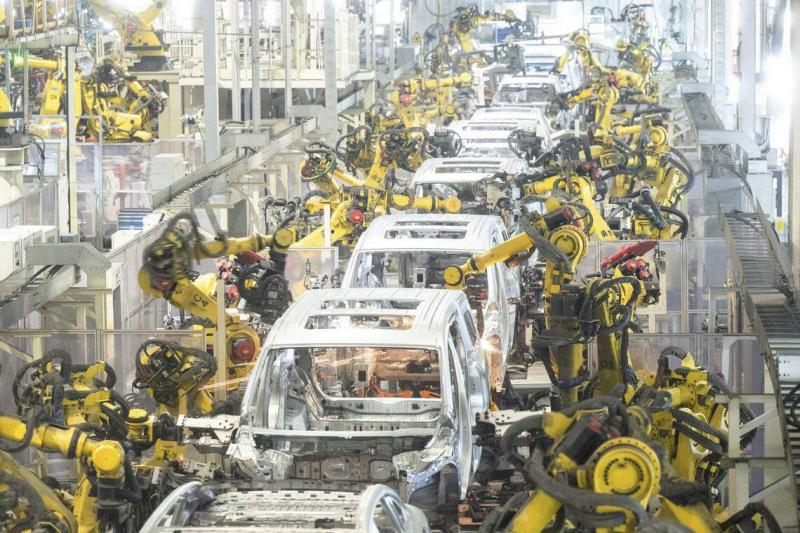 业内人士认为,从光伏、风电到电动汽车,中国新能源产品并非靠低价取胜,而是靠累积了多年的全产业链优势。图为湖北武汉的岚图汽车电动化焊装车间,机器人在流水线上作业。(新华社)