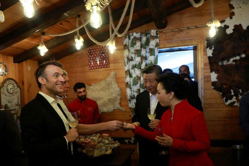 法国总统马克龙(左一)、中国国家主席习近平(右二)和夫人彭丽媛(右一)5月7日在“牧羊人的脚步”传统餐厅里品尝当地奶酪。(路透社)