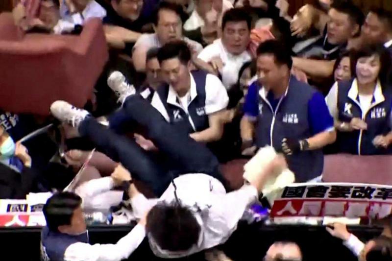 台湾立法院5月17日爆发混战,民进党立委沈伯洋在试图从主席台后门冲进议场时,不慎从高处被拉下,头直接着地,吓坏现场的民意代表。(路透社视频截图)