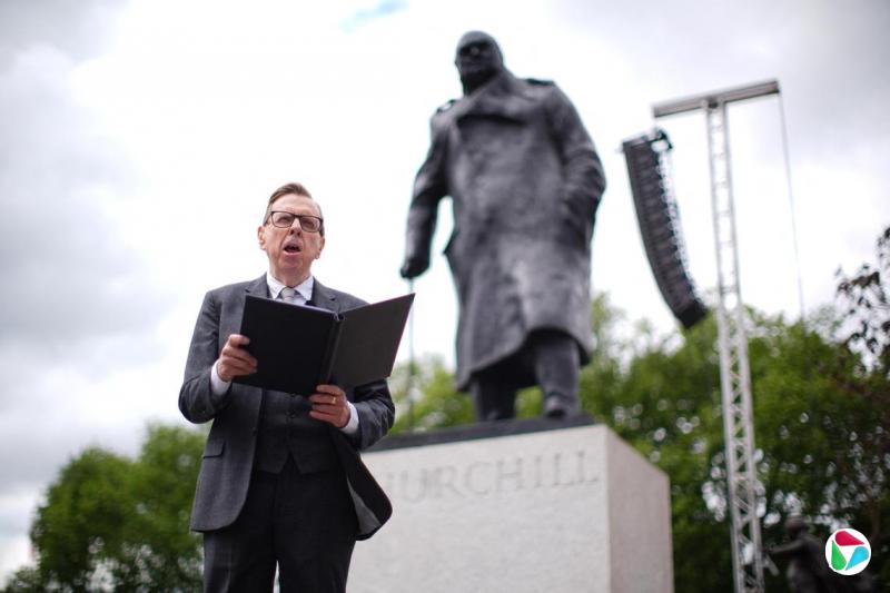 5月5日,英国名演员蒂莫西·斯波(Timothy Spall)在欧战胜利80周年庆典上朗诵战时首相丘吉尔在1945年的胜利演说。后面是丘吉尔雕像。(VIA REUTERS)